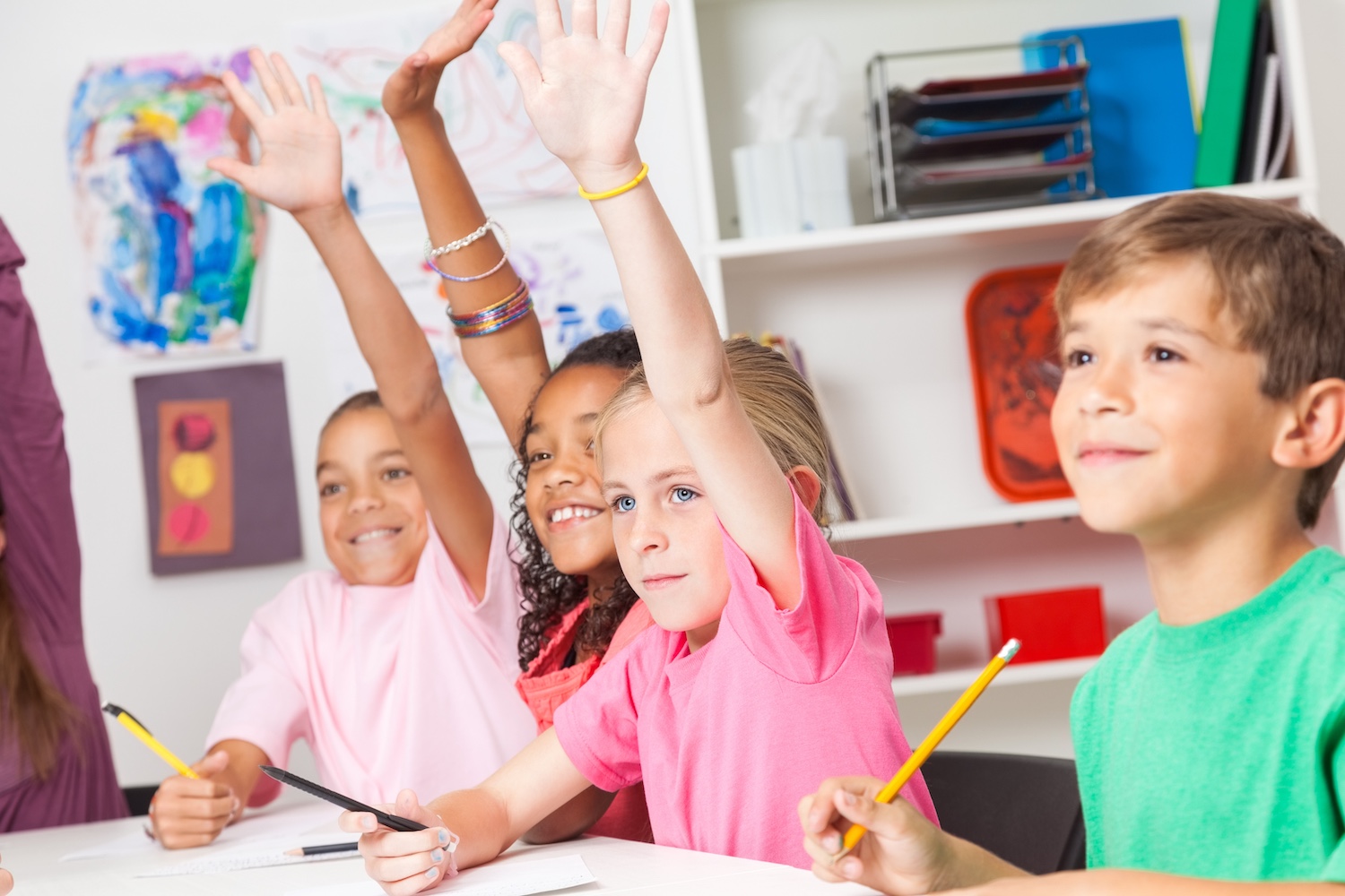 Simple Science Safety Lab Rules: A Guide for Your classroom This is a picture of elementary students raising their hands in a classroom while learning science safety lab rules during a lesson on classroom expectations.